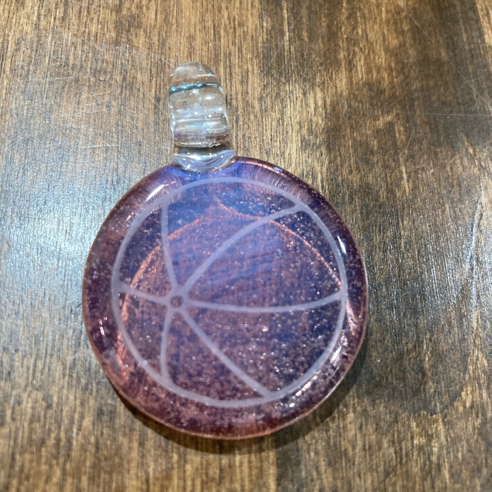 Glass pendant/charm rose in color w/outline of a beach ball.